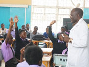 数学の公開授業。養成校教員が質問をなげかけ、生徒が積極的に手を挙げている様子。