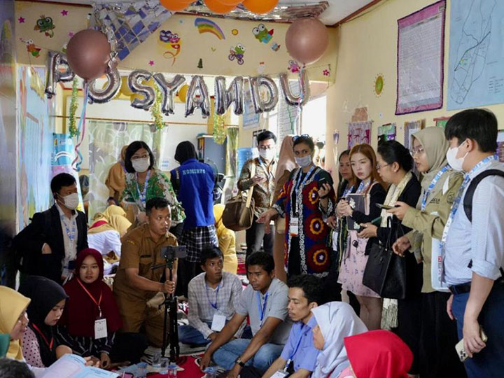 ▲ソロック市のWijaya Kusuma 5 Tanjung Paku村落統合保健ポストにて、日々の活動の説明を受ける参加者たち。写真は、母子健康手帳を活用した両親学級（子どもの健康）実施の視察中。