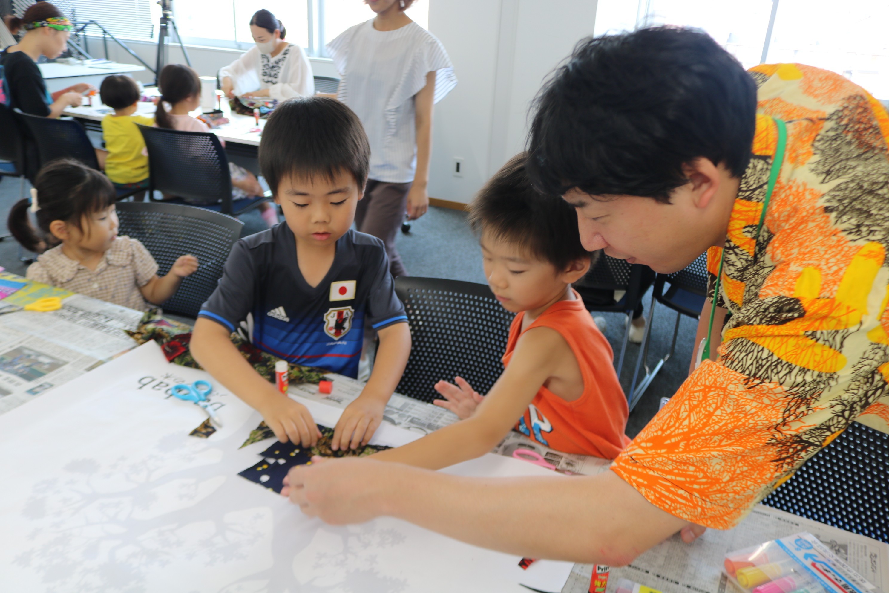 由地推進員さんとともに「バオバブの木」の共同作品づくりに取り組む子どもたち