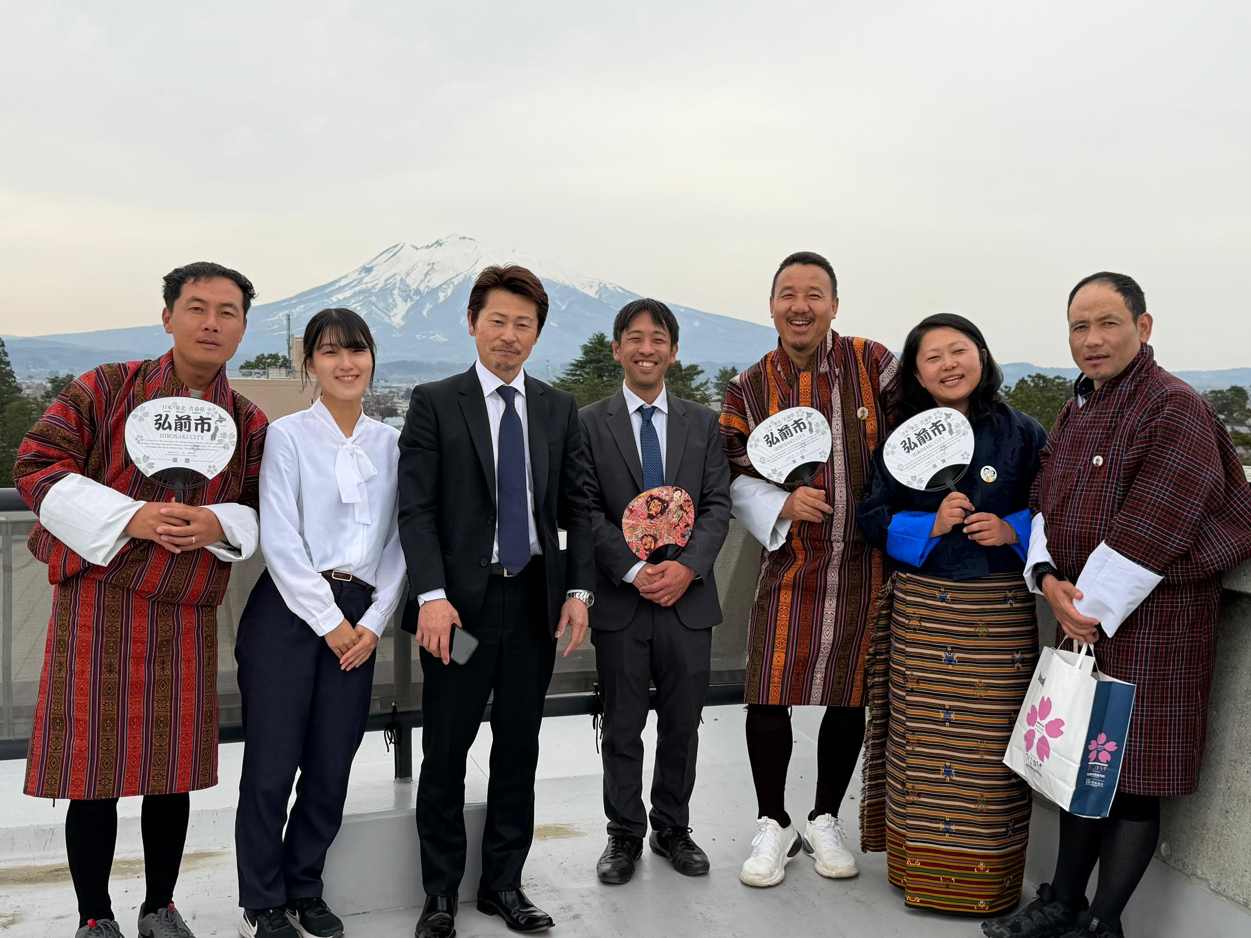 技術指導を担当した原田氏(左から３番目)、古川氏（中央）と研修参加者 （岩木山を背景に弘前市庁舎屋上にて）