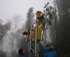 Engineers installing seismology equipment on the foggy slopes of Mt. Tungurahua