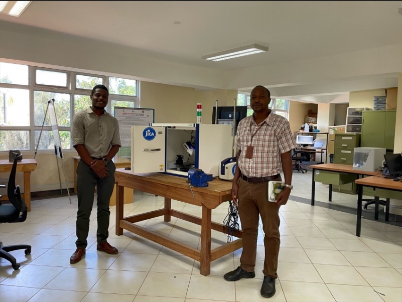 Fig. 2 Dr. James Mutua and his assistant in his laboratory, posing with the newly acquired Residual stress measuring machine.