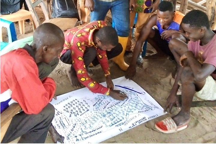 Villagers mapping the area, planning how the land will be used.