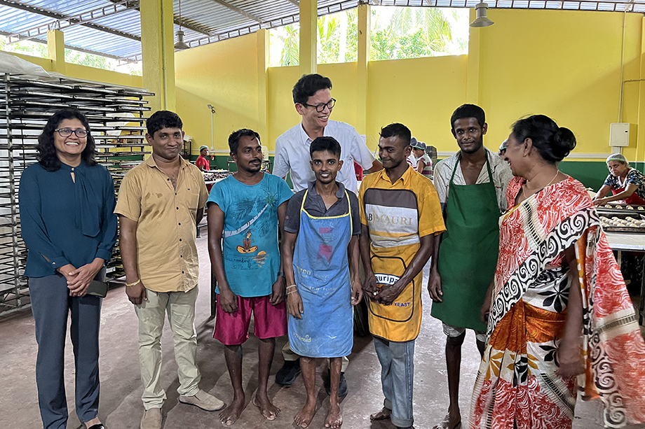 Persons with disabilities employed at a bakery through the JICA project, here seen with the company owner and government officials.