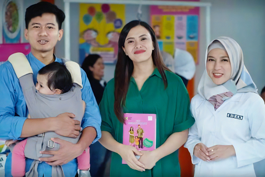 An Indonesian family holding a MCH Handbook