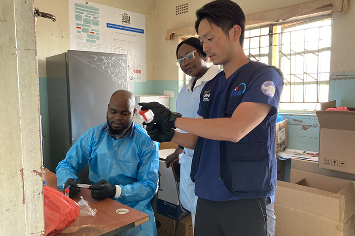 Imamura instructing local health care workers at a clinic on stool sample collection methods.