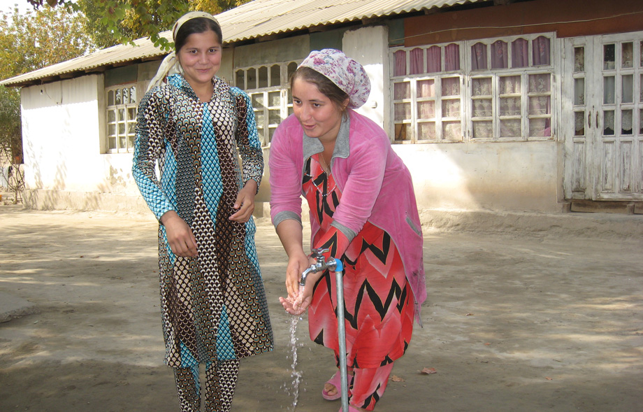 Residents of Tajikistan washing their hands at a public water facet.