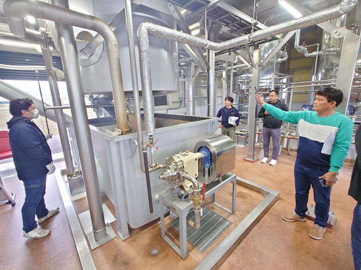 Trainees observe the treatment process during their waste cooking oil plant tour.