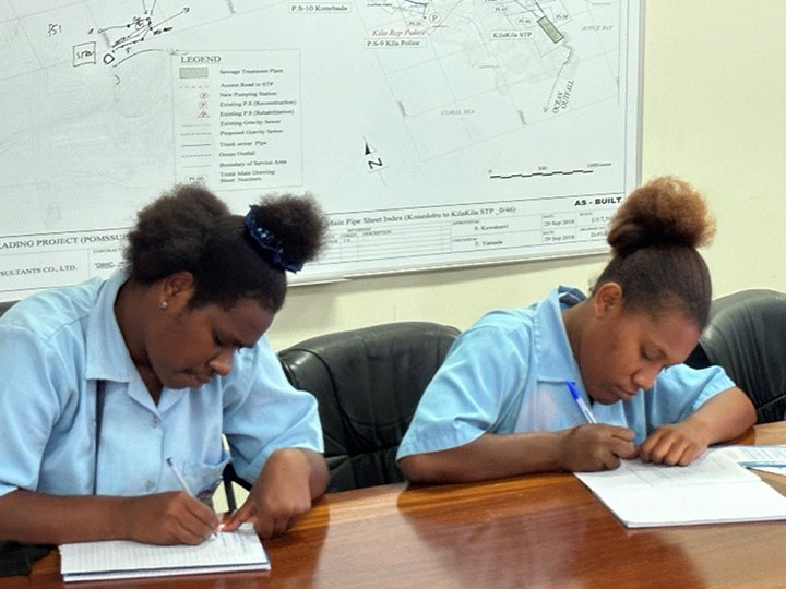 Students from Jubilee Secondary School taking notes during a presentation at POMSSUP.