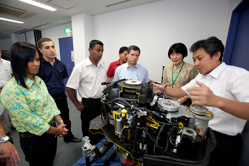 Des participants à une formation en ingénierie absorbés par les explications de leur instructeur.