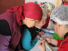 Les femmes apprennent à travailler la laine feutrée.