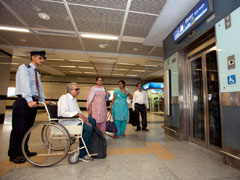 インドの地下鉄（デリーメトロ）の駅構内。車いす利用者の移動を職員がサポートしている