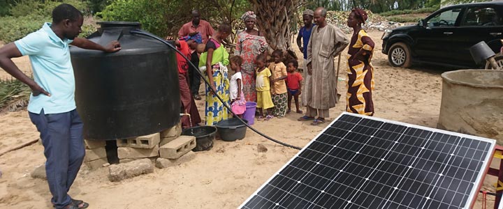 【After】太陽光パネルで発電した電気によって、手汲み井戸から電動ポンプで水を汲み上げる。水汲みの負担が減った女性は、農作業に時間を費やせるようになった。