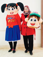 副校長のサミラ・ヨウセフさん（中央）と、日本のアニメをヒントにサミラさんが手作りした同校のオリジナルキャラクター「スゴイくん」（右）と「ステキちゃん」（左）。着ぐるみが歯磨きや手洗いのデモンストレーションを行い、子どもたちの興味を高める。