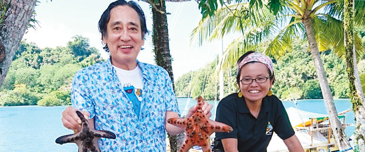 両手には巨大なヒトデ。元青年海外協力隊員の伊藤洋美さん（写真右）の案内でセンターを見学。