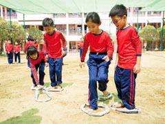 【小学2年生：輪っかジャンプ】2人1組で3本の輪っかを使い、相手の子が前に進めるように交代で輪っかを置いていく。ペアの子がうまく前に進めるように輪っかを置けるかな？