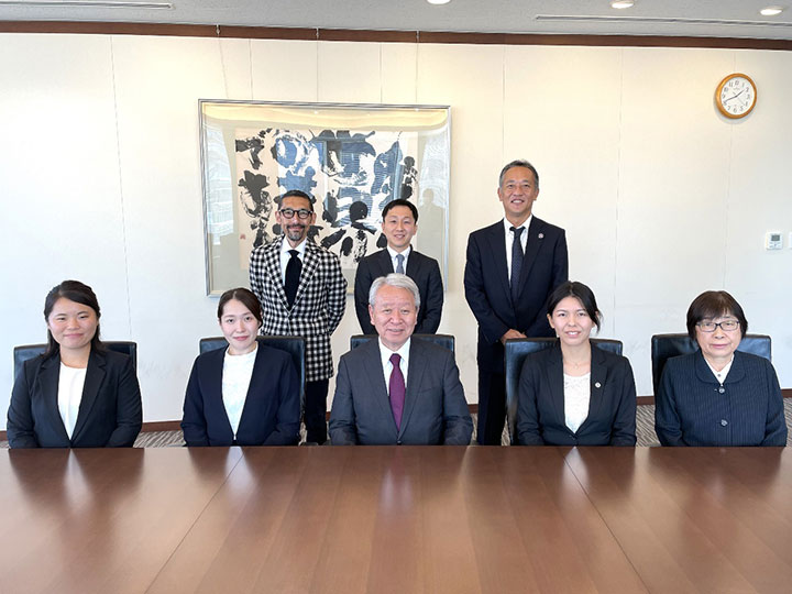 From left in the front row are Ms. Ishii, Ms. Kanzaki, President Tanaka, Ms. Usui, and Ms. Izumi. In the back row from left are Mr. Otsuka, Chief Secretary of the Office of the President; Mr. Kitagawa; and Mr. Tachibana, Director General of JOCV.