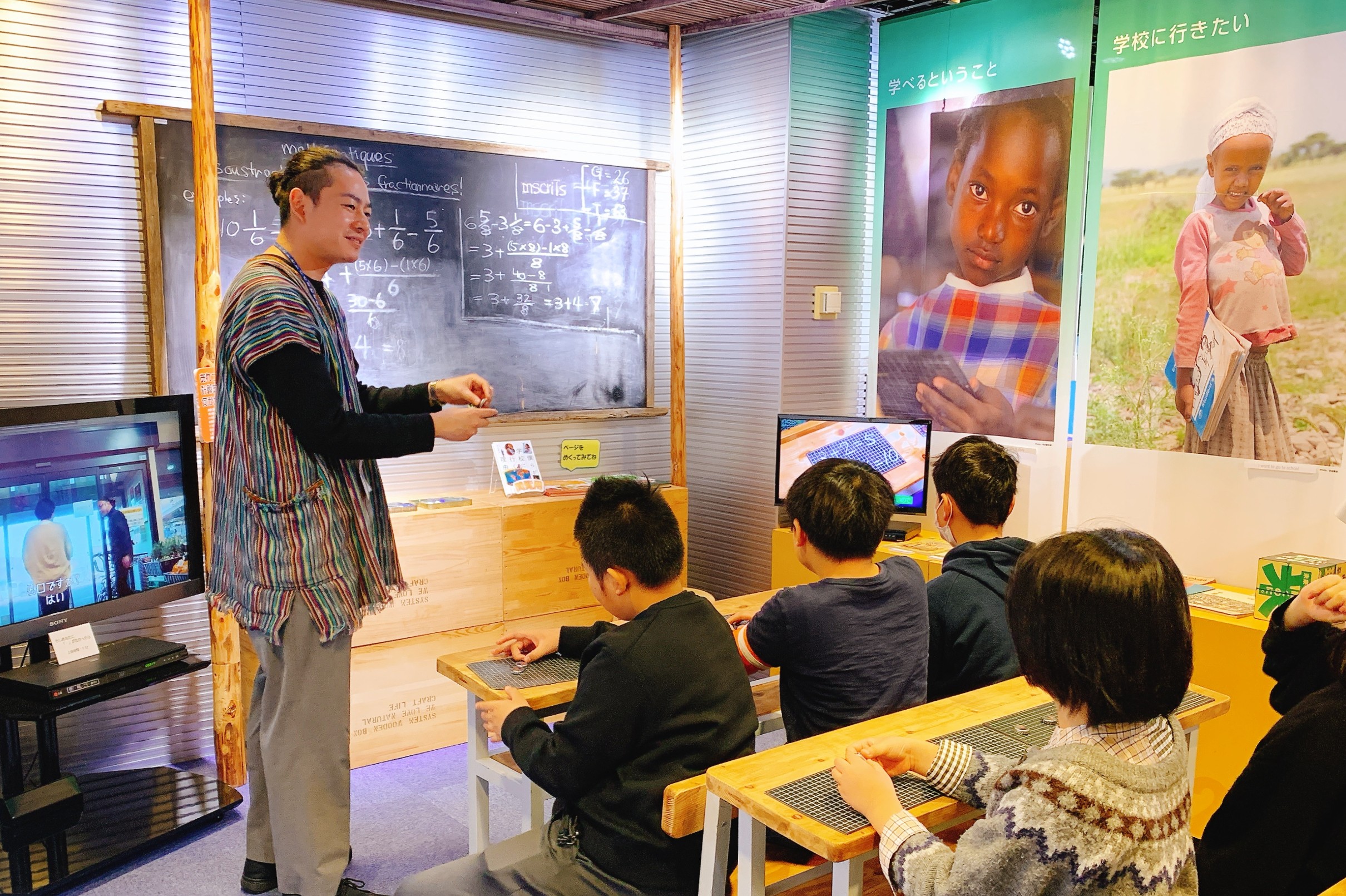 途上国の学校を再現した展示で、疑似体験する子どもたち
