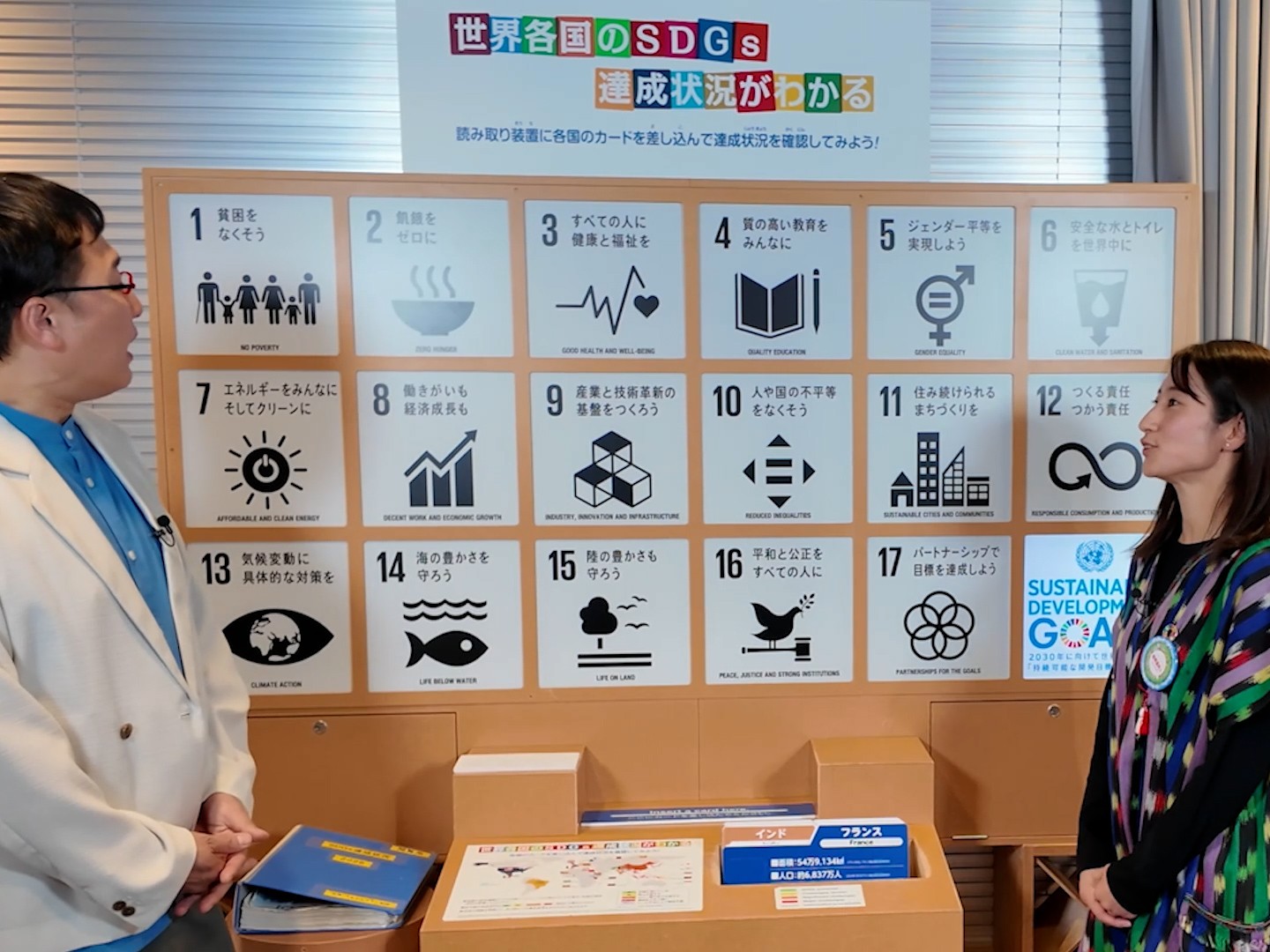 SDGsのボードの前に立つ山里さんと三國由菜・地球案内人 