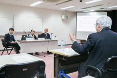 参加者と議論する志賀主任研究員(左)