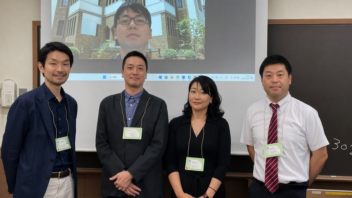 写真：（スクリーン）鈴木淳平講師、（前列左から）室谷龍太郎企画部審議役兼次長、阪本拓人教授、折田朋美主席研究員、長辻貴之研究員（肩書は開催当時）