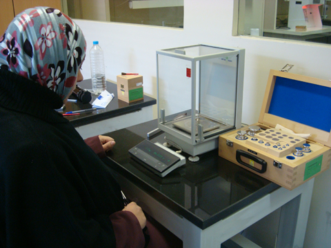 標準分銅セットと電子デジタル秤を使って計測するヨルダン人技師。