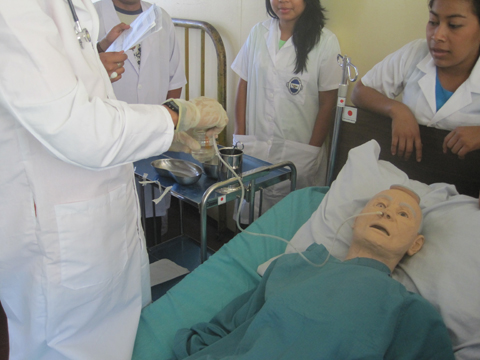 胃管挿入：学生が放課後に実習用モデル（人形）を使用し、胃管の挿入方法を練習している様子。