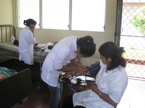 血圧測定：供与された血圧計、聴診器を使って、学生が放課後に血圧測定の練習をしている様子。