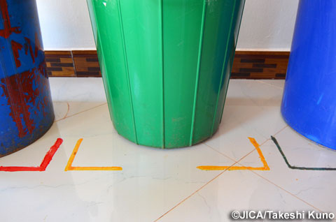 床に貼られたカラーテープにより、各ゴミ箱の定位置と内容物が明確にされている。5S-カイゼンが進んでいる証拠。（写真提供：久野 武志）