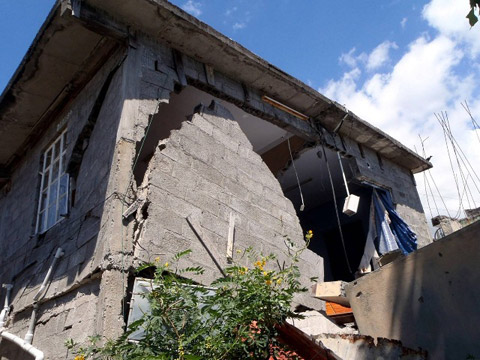 地すべりの進行により発生した家屋の被害状況。写真は、首都ポートルイス市において発生した地すべりの一つ。