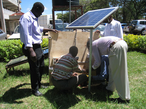 独立型太陽光発電システム（SHS）の短期研修コース（TOT）の参加者と指導をするカウンターパート（写真中央）。