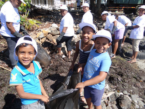 清掃活動で楽しそうに海岸のゴミを拾う子供たち。