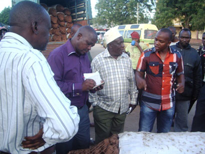 ジャガイモ市場調査。輸送業者から聞き取りをするプロジェクト関係者、普及員、農家。