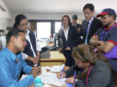 実地調査を見守る佐久間JICAネパール事務所長（写真後列右から2人目）ら。センサスの調査対象である事業所がその場で回答してくれる場合には、調査員が聞き取って調査票に記入します。