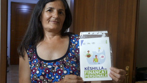 「家計簿」金融教育ブックレットを手にする女性（Tapelena村）