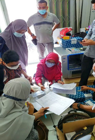 インドネシア保健省のカウンターパートと機材納品時の検品作業