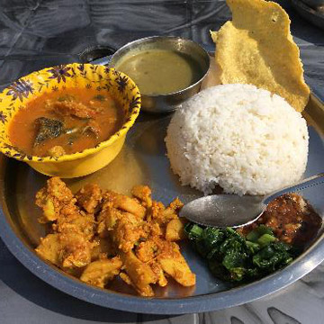 一番上：豆スープ、左のボウル：魚カレー、左下：野菜のカレー炒め、右下：青菜炒めと辛いピクルス。パパッドと呼ばれる揚げ煎餅も付いてきます。