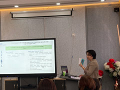 製本された研修病院評価基準を手に、研修の講師を務める保健開発センターの担当官