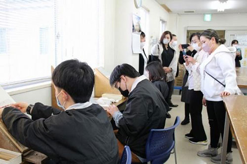 就業生活に備えてさまざまな作業に取り組む様子を興味深そうに視察する研修員たち