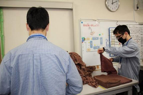 ホテルや病院の業務に多いタオルの四つ折り作業に取り組む利用者たち