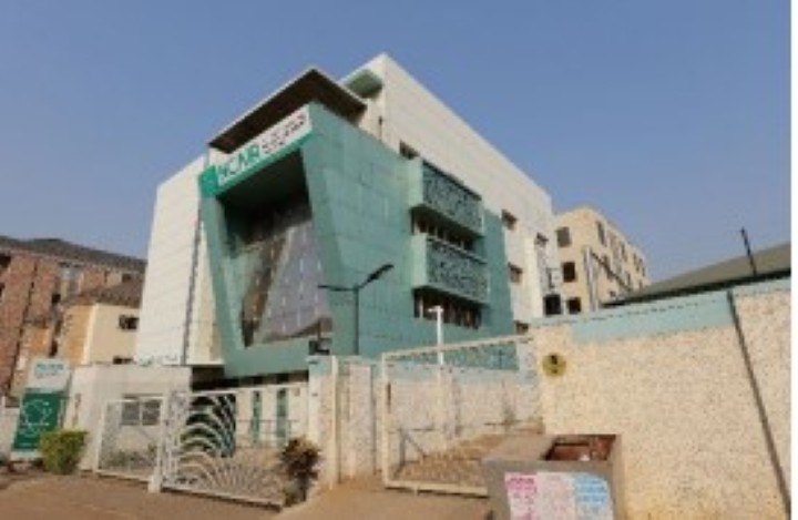 NCAIRとONDIの入る既存建物。現在駐車場として使われる建設予定地とは、擁壁で仕切られ出入りは前面道路を介している。