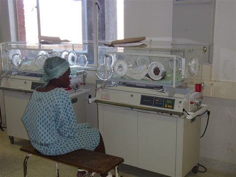 新生児室で1998年に供与された保育器に入る新生児とその母親