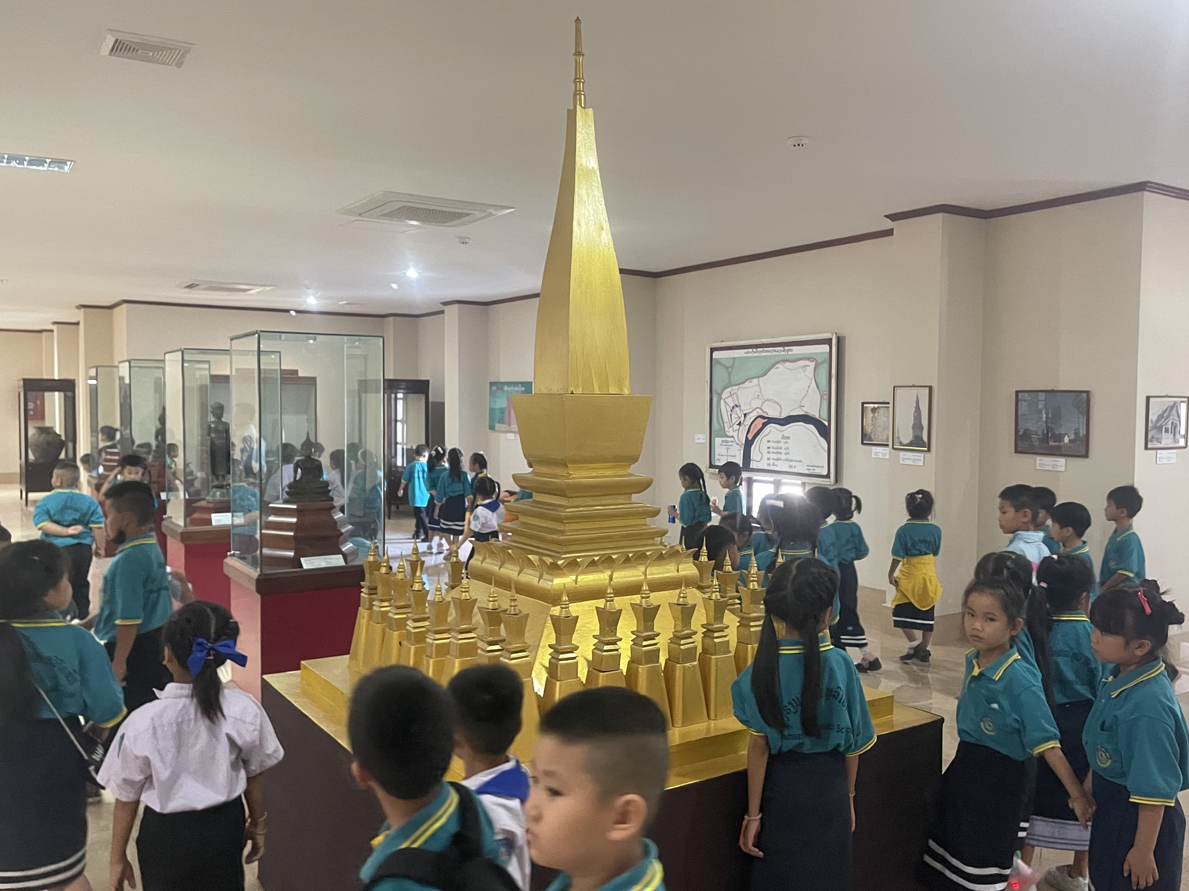 09 Miiniature replica of That Luang with Lao students visiting the museum