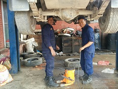 ネパール警察の車両整備工場で整備の様子を見る平川さん。「ほとんどの車両の整備作業は屋外でしかできず、土ぼこりが舞うなかでの作業には正直、戸惑いました」（平川さん）