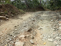 舗装前の道路。急斜面かつ石だらけで事故が多発していた
