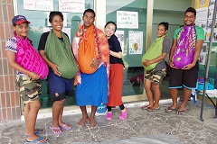 「妊婦体験ができるジャケット」を着用した若者たちと嶋谷さん（右から3人目）。「キリバスの女性がよく腰に巻いている一枚布“ラバラバ”、ごみ袋、土7kgの三つで作製しました」（嶋谷さん）。妊娠約8～9カ月の妊婦体験ができる