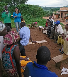 隊員時代、ウガンダの住民会議でSUNDAシステムのコンセプトを説明する坪井さんと村人たち