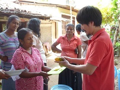 家庭を回って通気性の良い容器を配り、コンポストのやり方を説明する飯野さん