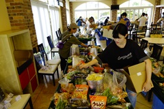 食材配達前の準備。コンテナにその日の食材を分けて入れていく。2人一組に分かれ、ドライバーの車にコンテナを載せて配達開始