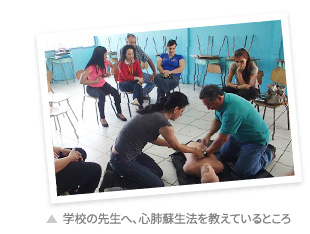 学校の先生へ、心肺蘇生法を教えているところ